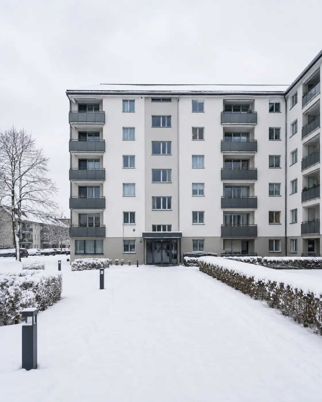 Zuweg einer Wohnanlage nach dem Schneefall, Pflaster und Rasenkante vollständig unter Schnee