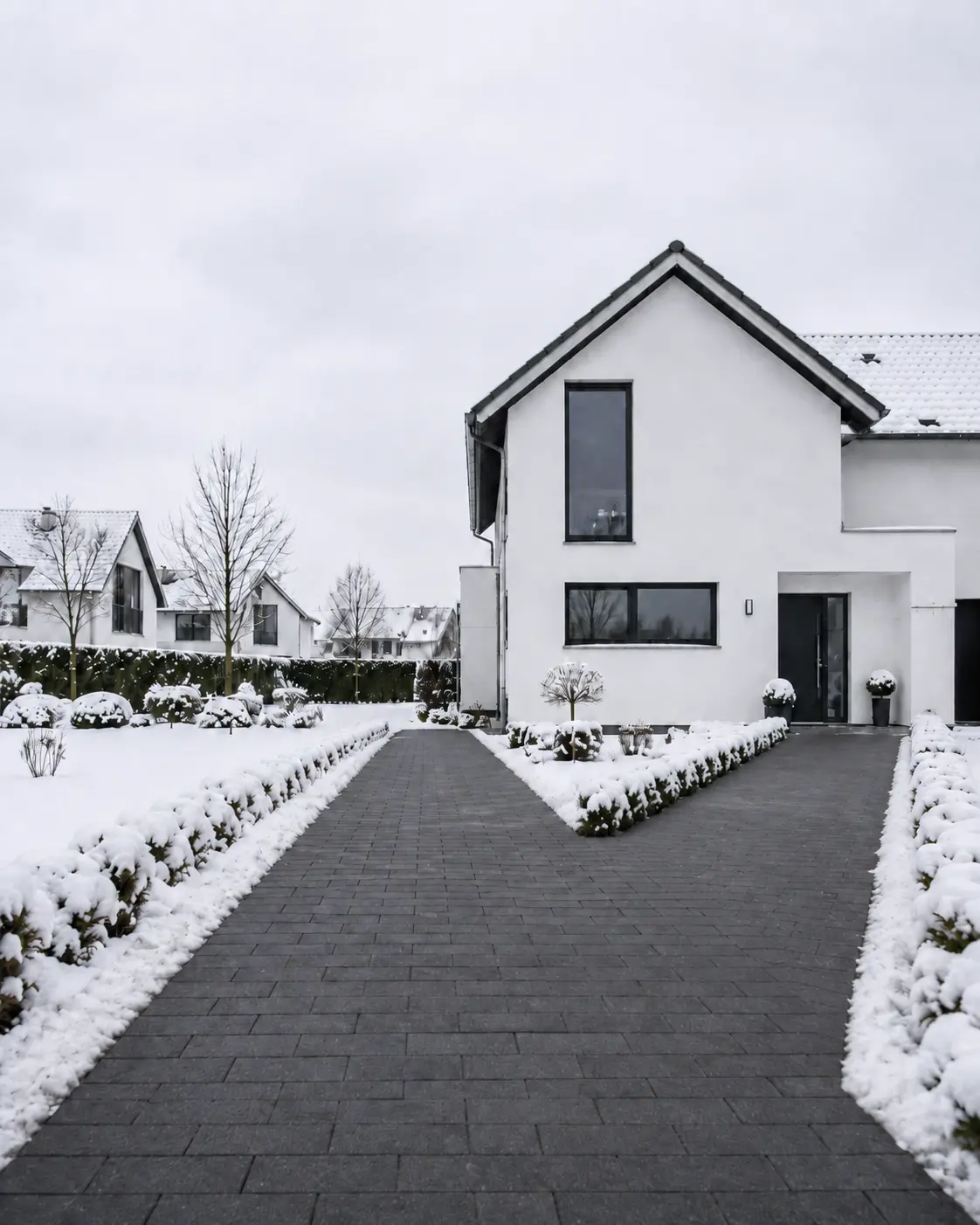 Geräumte Einfahrt und geräumter Zuweg eines Einfamilienhauses nach dem Winterdienst von RELTRO
